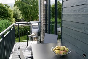 A balcony with a table, chairs, and a bowl of fruit. - Refugium 7 (Kellenhusen)
