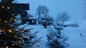 Un paysage enneigé avec une maison et un sapin de Noël.