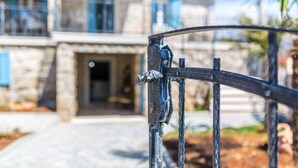 Een stenen huis met een metalen hek op de voorgrond.