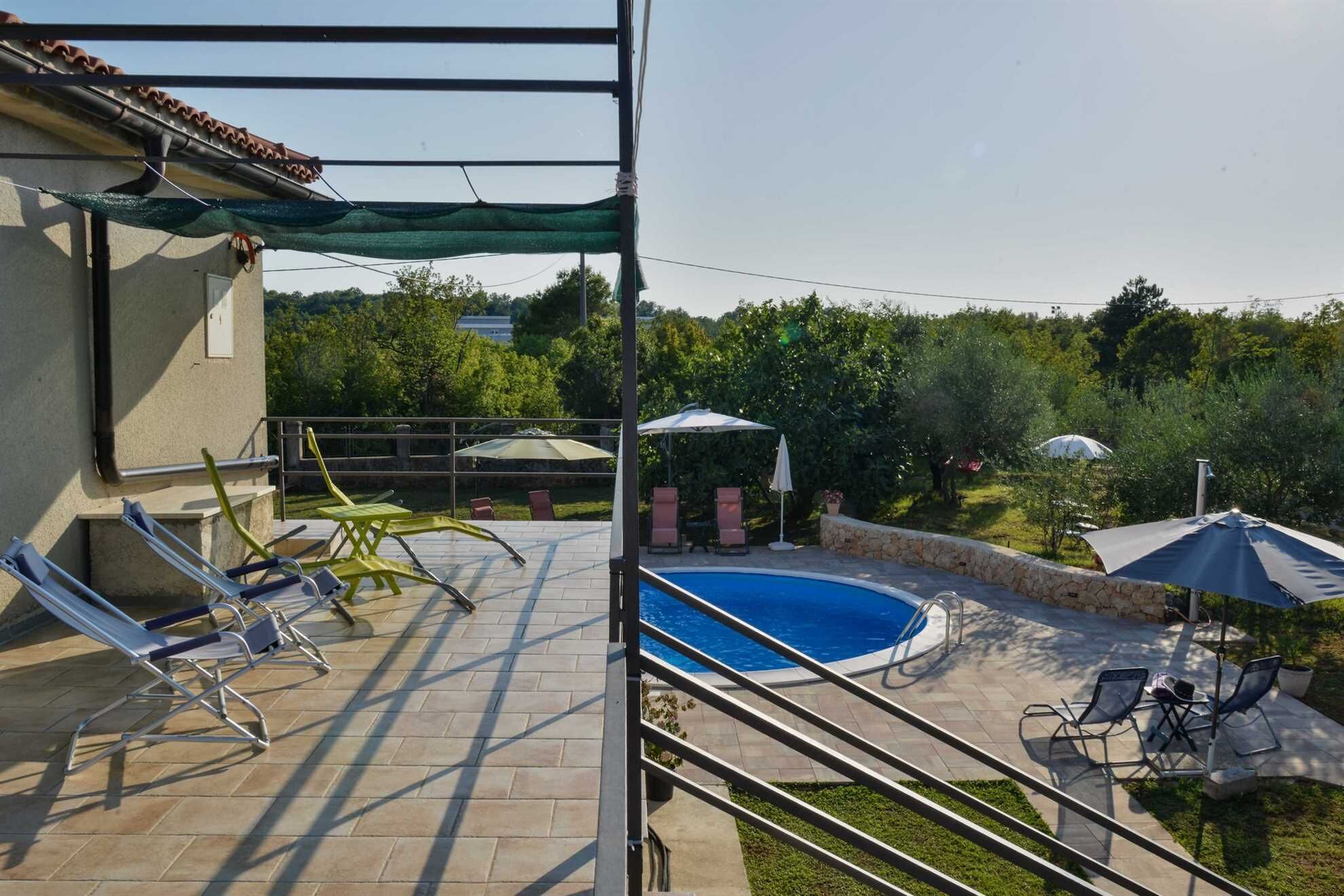 A backyard with a swimming pool, outdoor furniture, and a pergola.