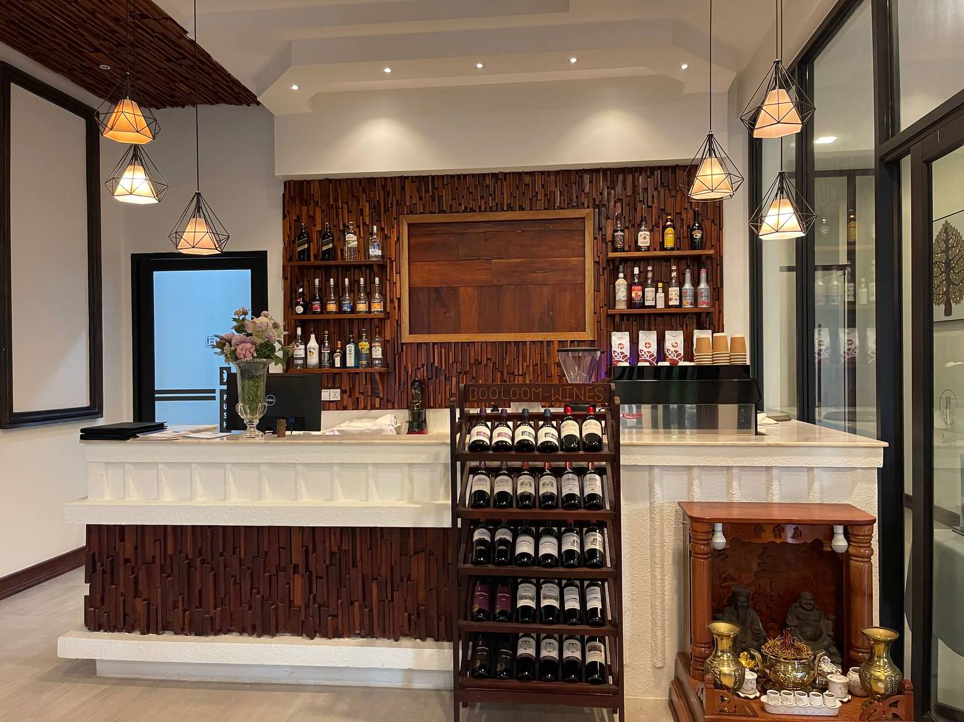 Una zona de bar con paneles de madera, estanterías llenas de botellas de licores y una vitrina de vinos.