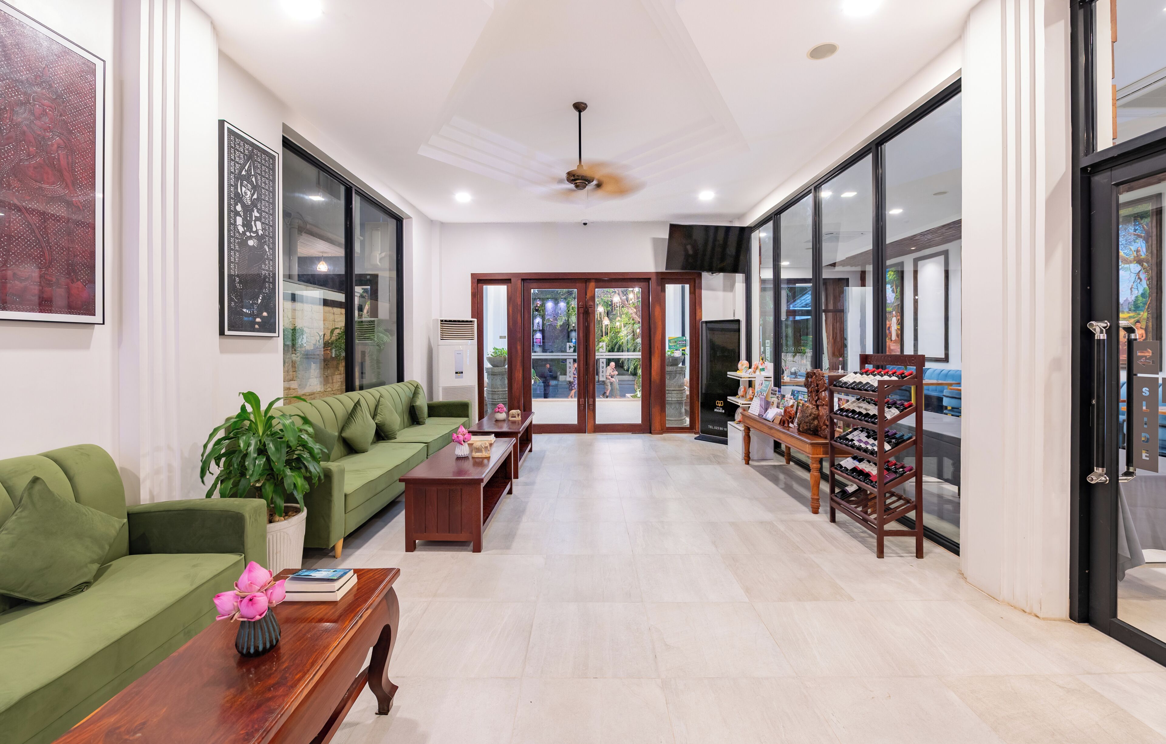 A spacious living area with a green sofa, a wooden coffee table, and a wine rack.