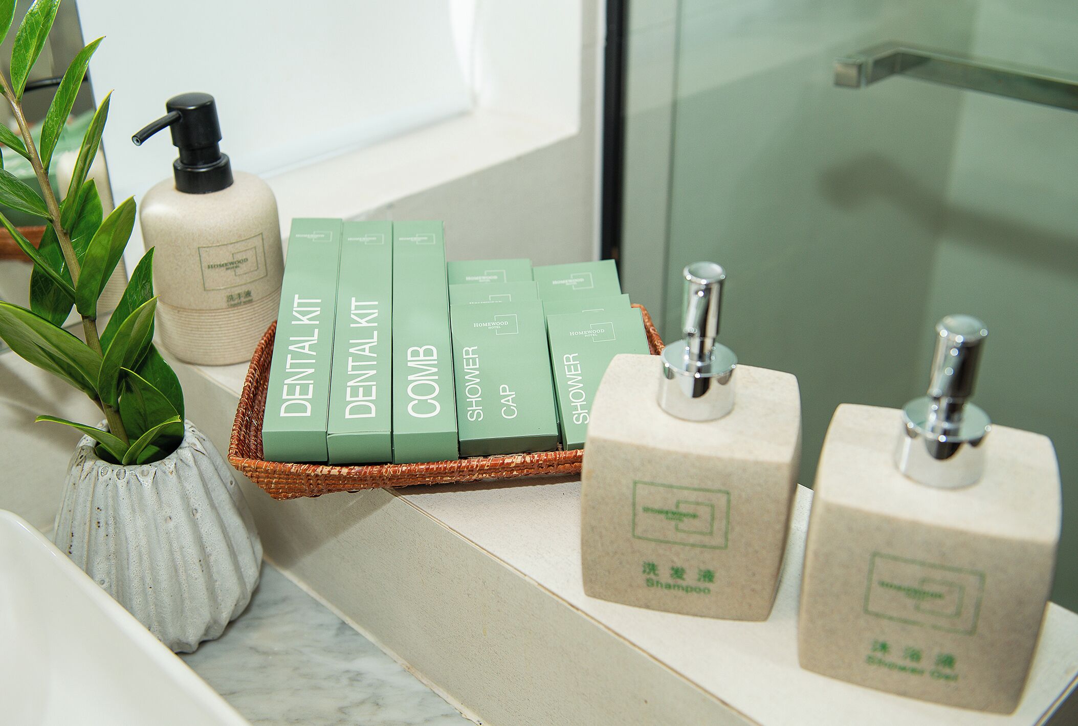 Een badkamer met een plant, een fles en een mand met groene dozen, gelabeld 'DENTAL KIT'.