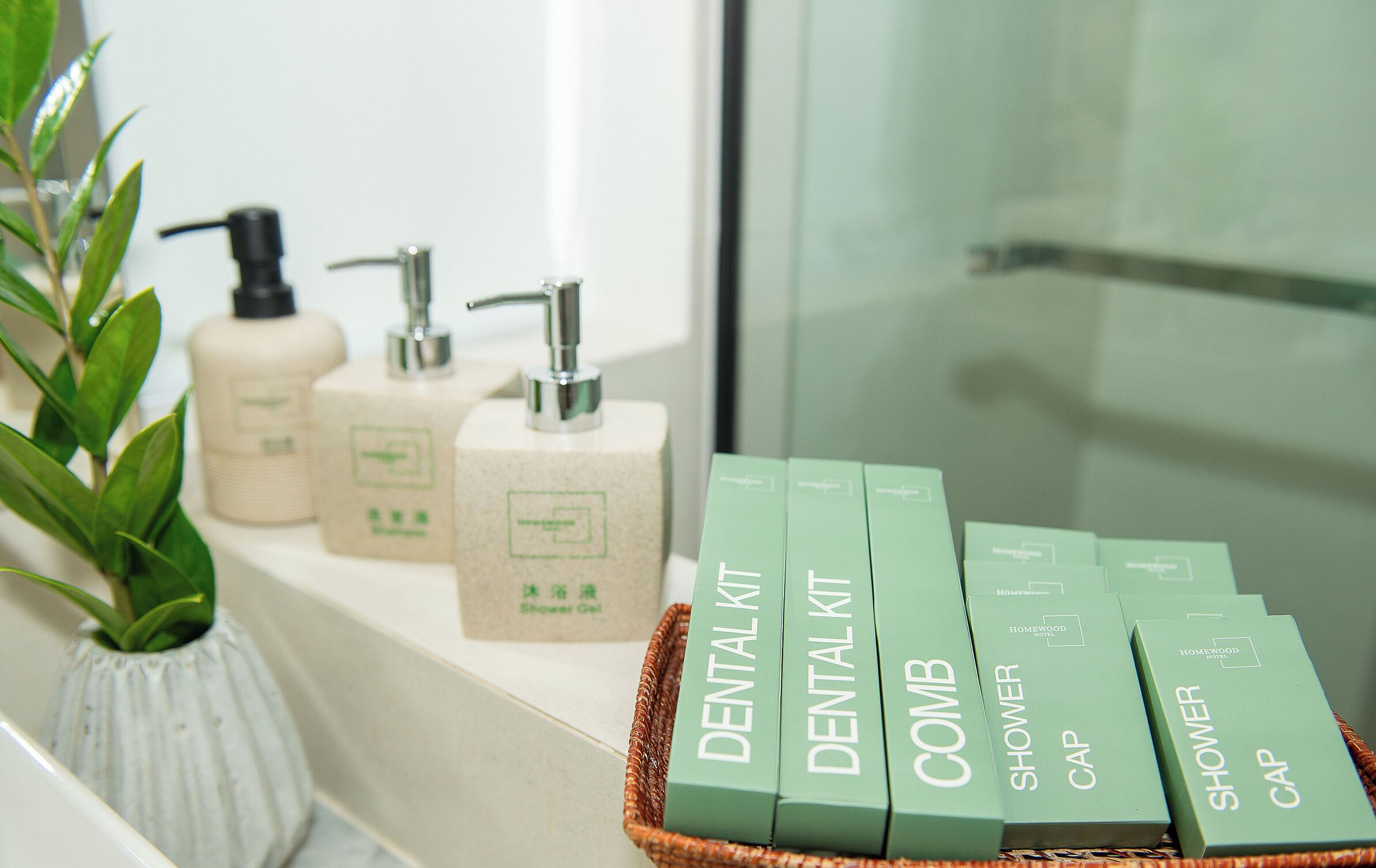 A bathroom with a sink, a plant, and a basket containing dental care products.