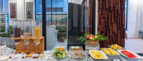A buffet with various food items and a glass display case with snacks.
