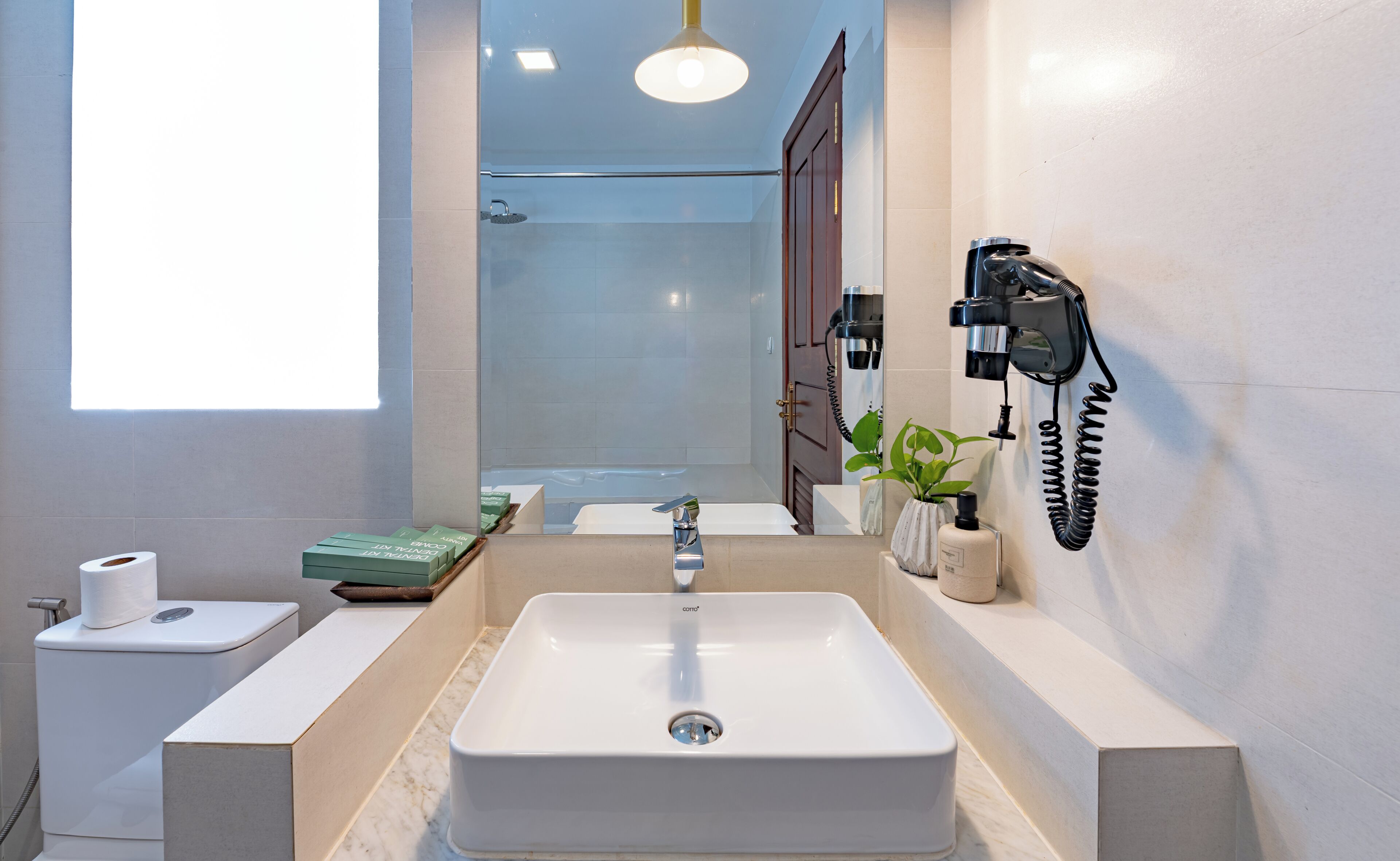 A bathroom with a large sink, toilet, and shower.
