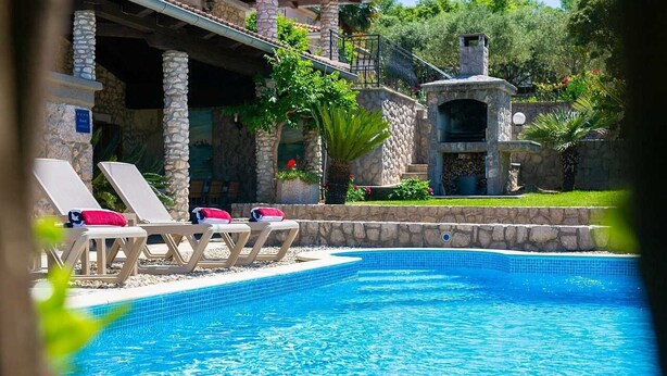 A swimming pool with lounge chairs and a stone building with a barbecue area. - Villa Magdalea With Swimming Pool And Seaview (Hlapa (Krk))