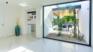 A modern interior with a large glass door leading to an outdoor patio area. - Casa Bela with heated pool and luxury of 5 stars (Klimno (Krk))