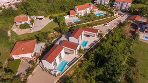 A residential area with modern houses, each featuring a swimming pool and a red-tiled roof. - Casa Bela with heated pool and luxury of 5 stars (Klimno (Krk))