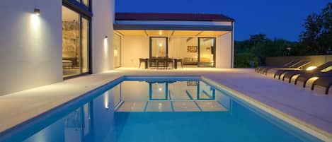 A heated pool, sun loungers