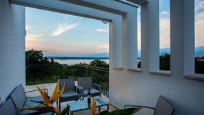 A balcony with a view of a lake and mountains, furnished with chairs and a table. - Villa Zarra with heated pool, jacuzzi, sauna and Seaview (Klimno (Krk))