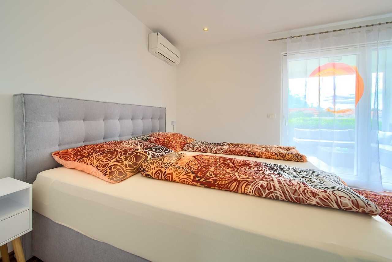 Une chambre d’hôtel avec un grand lit, une table de chevet et une fenêtre avec des rideaux.