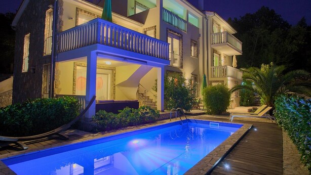 A two-story house with a swimming pool, a covered patio, and a wooden deck. - Residencia La Famiglia with heated swimming pool and beautiful Seaview (Klimno (Krk))