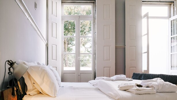 Une chambre d’hôtel avec un lit, une fenêtre et une porte.