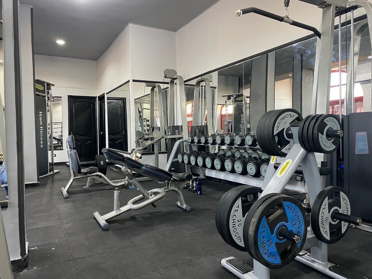 A gym with weightlifting equipment, including dumbbells and benches.