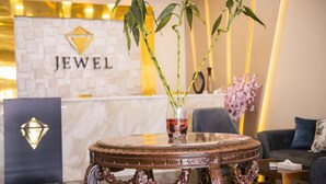 A reception area with a marble counter, a decorative table with a vase of green plants, and a sign that reads "JEWEL". - Jewel Port Said Hotel (Port Said)