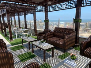 A rooftop terrace with outdoor furniture, a pergola, and a view of the cityscape.
