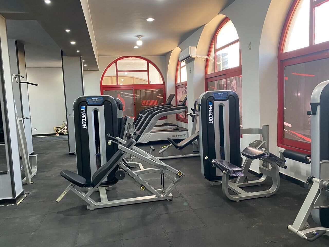 A gym with various exercise machines, including a leg press and a chest press.