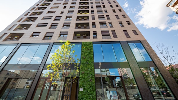A modern high-rise building with multiple floors, large glass windows, and a vertical garden feature. - Central Chic Apartments (Tirana)