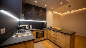 A modern kitchen with a built-in oven, a microwave, and a sink. - Central Chic Apartments (Tirana)