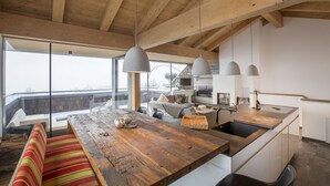 Una cocina moderna con techo de madera, ventanas amplias y una isla central con asientos.
