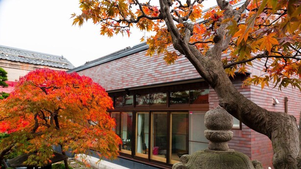 A traditional Japanese building with a tiled roof and large windows.