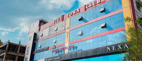 Un edificio de varios pisos con un letrero de 'Five Town Club', un letrero del 'Hotel Opera Inn' y un letrero de 'Nexa'.