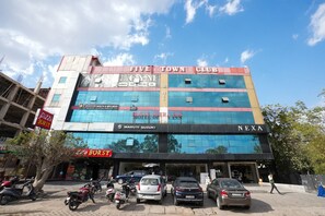 A multi-story building with a gym, a hotel, and a car dealership. - Hotel Opera Inn near Central Bus Stand (Udaipur)