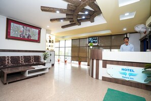 A hotel reception area with a modern design, including a reception desk, seating area, and a large framed artwork on the wall. - Hotel Opera Inn near Central Bus Stand (Udaipur)