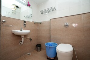 A bathroom with a sink, toilet, and a trash bin. - Hotel Opera Inn near Central Bus Stand (Udaipur)