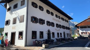 A two-story building with multiple windows, some with flower boxes, and a sign that reads "Albergo Riviera". - Hotel Bivera Sauris (Sauris)