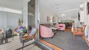 Un amplio salón con sofá, sillas, una mesa de comedor y una cocina al fondo.