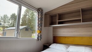 Una camera da letto con un letto, una finestra e scaffali in legno a muro.