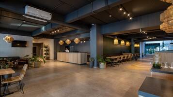 A spacious lobby with a reception desk, seating area, and modern lighting fixtures.