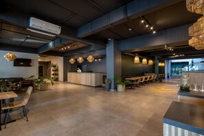 Un vestíbulo amplio con mostrador de recepción, zona de estar e iluminación moderna.