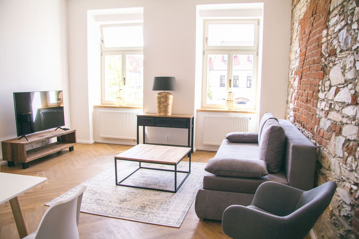 A living room with a TV, sofa, coffee table, and a lamp.