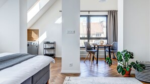 Une chambre moderne avec un lit, un bureau et un coin repas.
