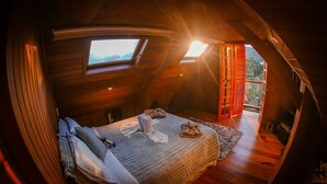 Un dormitorio acogedor con cama, ventana y vistas al exterior.