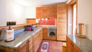 A kitchen with wooden cabinets, a stove, and a tiled backsplash.
