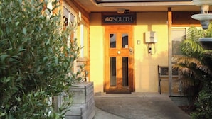 Entrada d'hotel amb una porta de fusta, un rètol que diu "40 SOUTH" i una font d'aigua a la dreta.