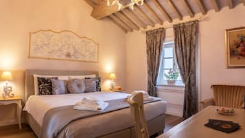 Un dormitorio elegante con una cama grande, lámparas de noche, una mesa de comedor y un candelabro.
