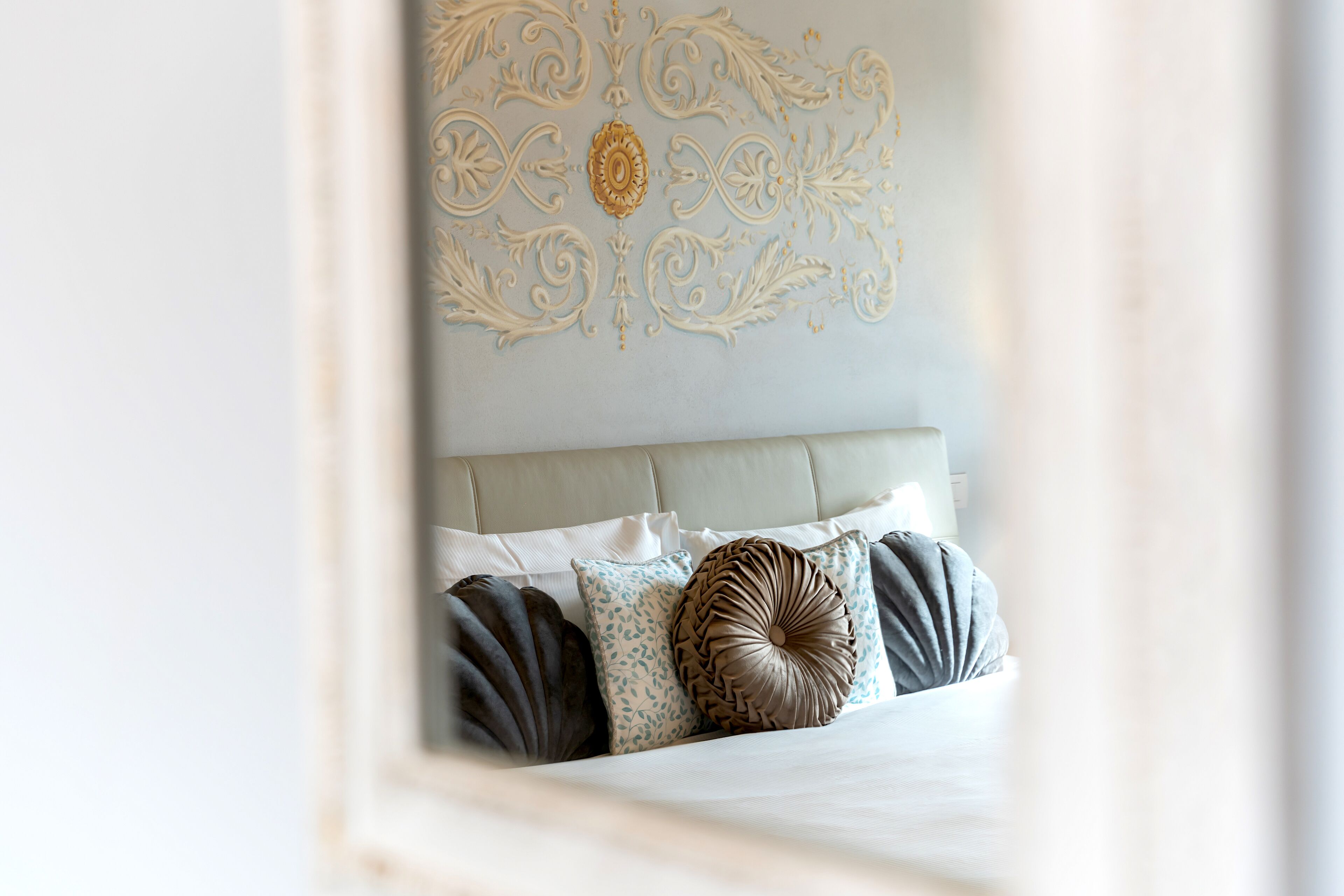 Un dormitorio con cama, almohadas y un adorno en la pared.