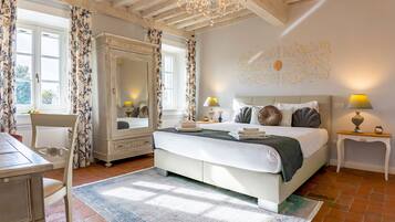 Une chambre à coucher avec un grand lit, une commode, une chaise et un bureau.
