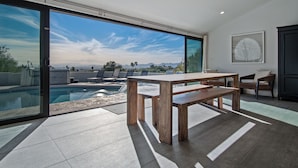 A modern outdoor dining area with a pool, large windows, and a view of the landscape. - Skyline: 5 bed/6 bath, amazing views, tennis & basketball courts, pool, hot tub (Catalina Foothills)