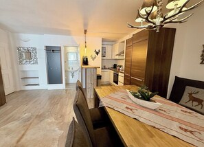 Une cuisine moderne avec une table en bois, un lustre et une décoration murale sur le thème du cerf.