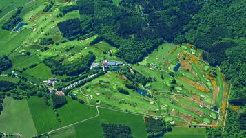 Vista aérea de un campo de golf con múltiples zonas verdes, búnkeres y obstáculos acuáticos.