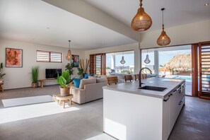 A spacious living area with a sofa, a TV, and a dining table.