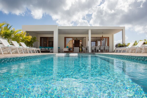 A modern pool area with lounge chairs and a clear blue pool. - Amazing luxury villa on Vista Royal Jan Thiel, seaview only 3 min. to the beach. (Vista Royal Q17)