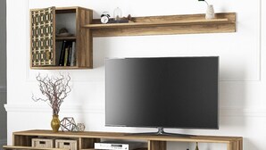 A modern entertainment unit with a flat-screen TV, wooden shelves, and decorative items.