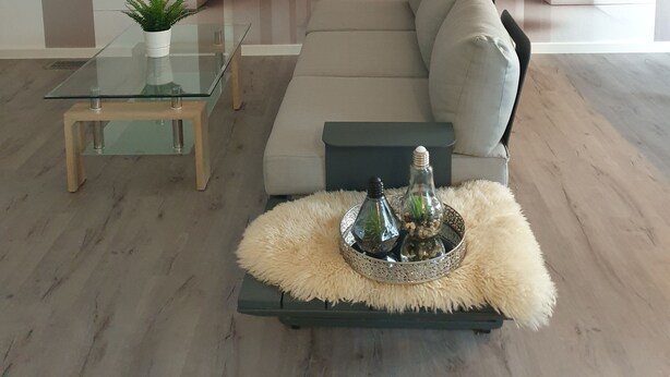 A modern living room with a glass coffee table, a beige sofa, and decorative spherical structures.